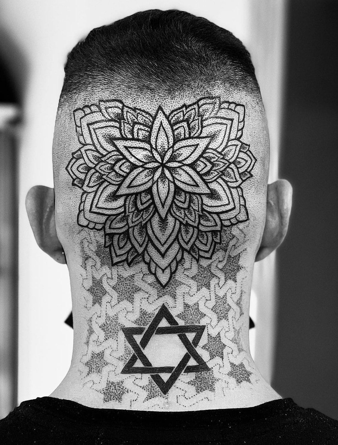 Mandala floral en pointillé à l’arrière du crâne rasé, prolongé sur la nuque par une étoile de David et un motif géométrique