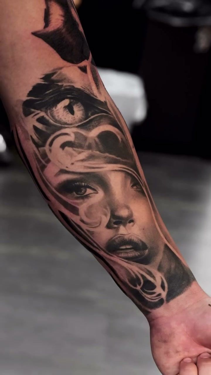 Visage de femme entouré de volutes sous un grand œil félin, réalisme noir et gris cicatrisé sur l’intérieur de l’avant-bras