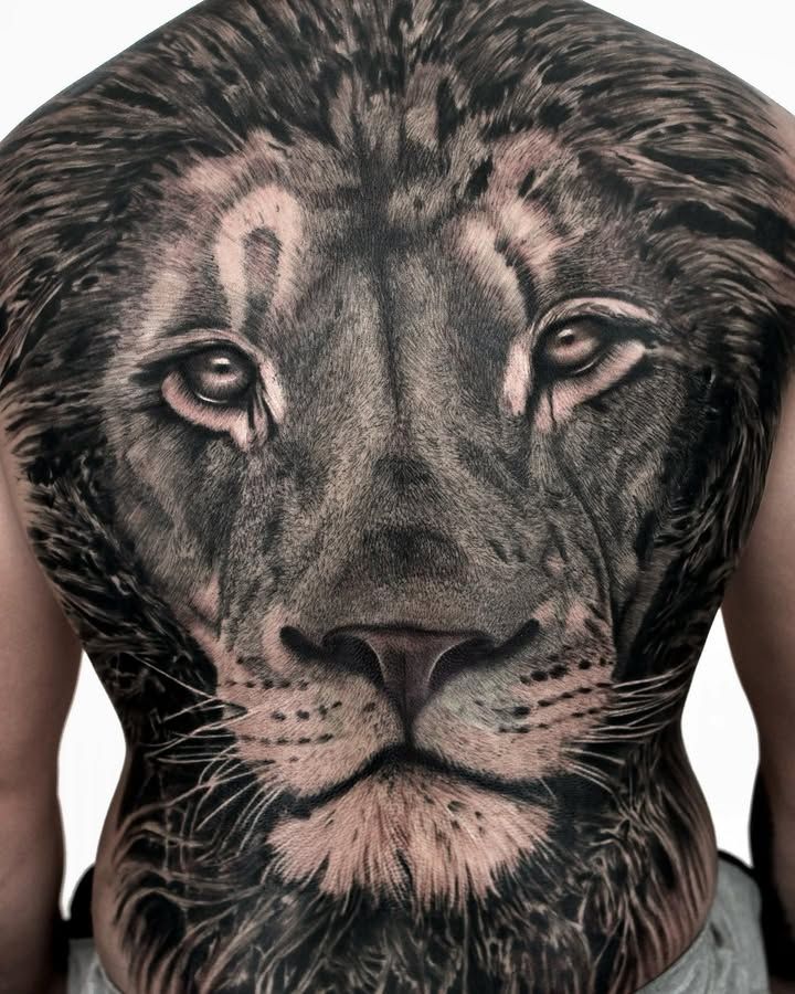 Visage de lion vu de face couvrant tout le dos, crinière sombre, moustaches et yeux clairs, en réalisme noir et gris